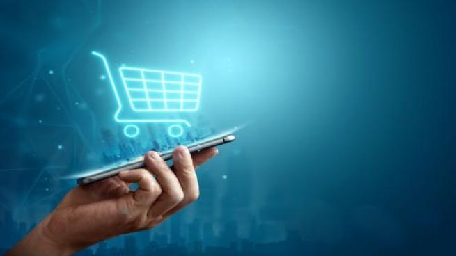 ecommerce shopping cart coming out of phone being held in hand